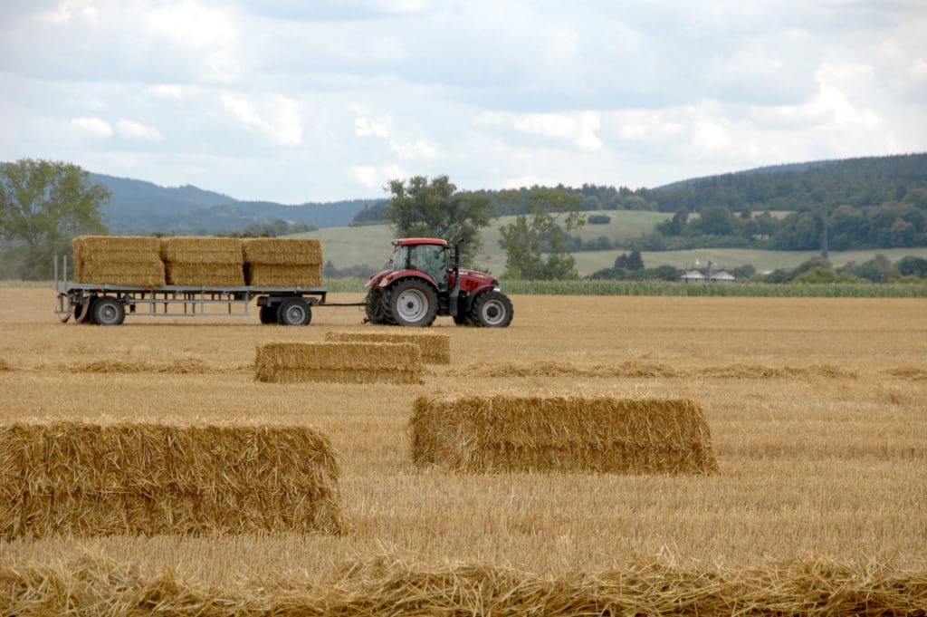 Ein Traktor fährt Stroh von einem Acker