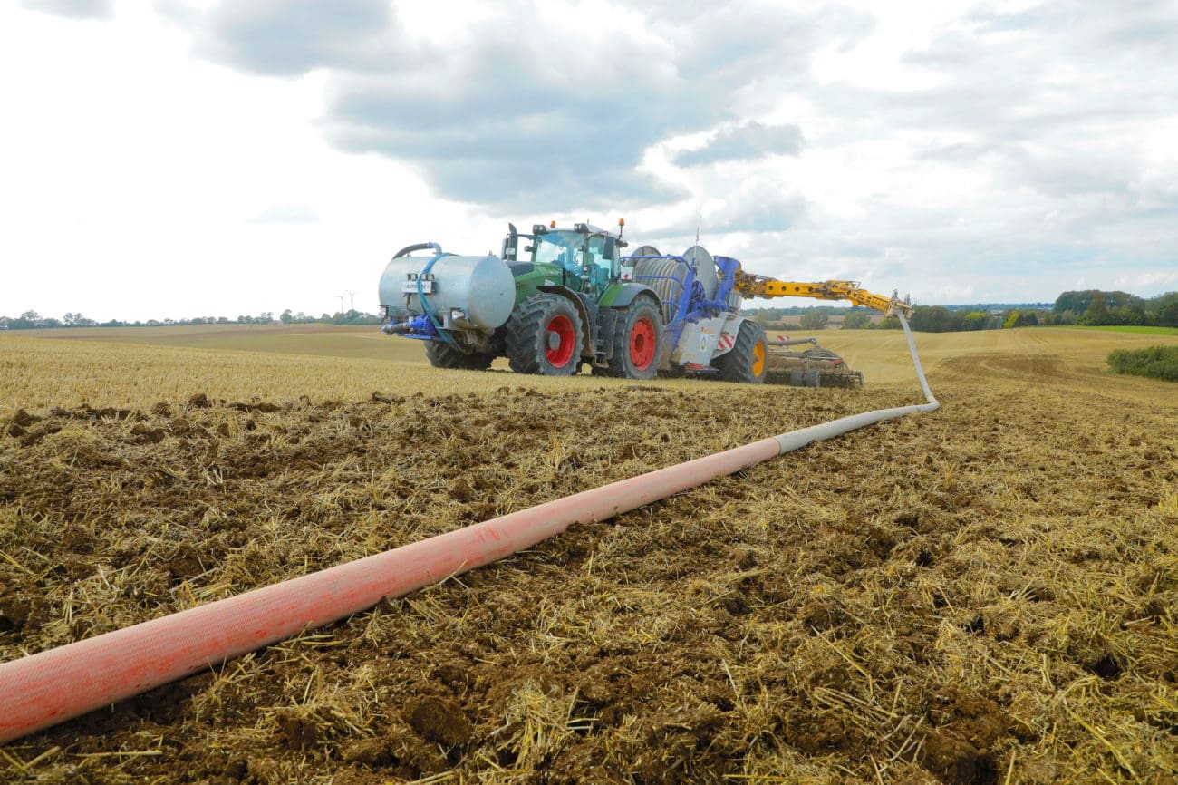 Traktor beim Gülle ausbringen mit dem Schlauch