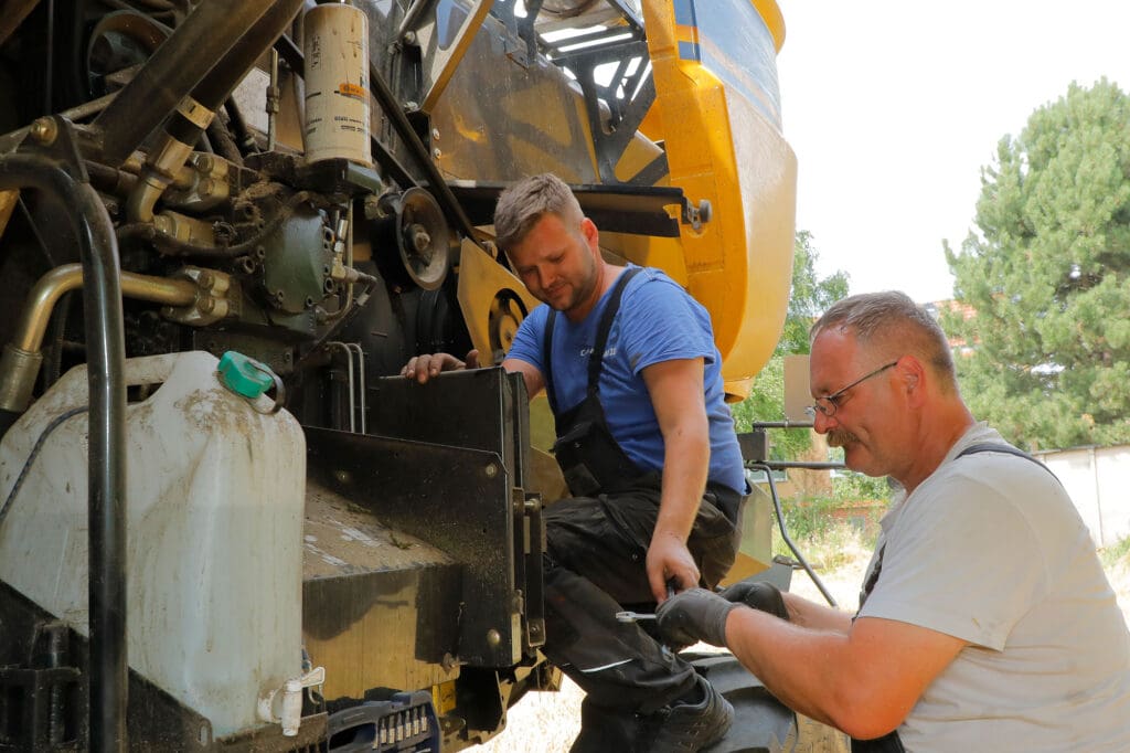 Landmaschinenschlosser André Mahnkopf prüft den Keilriemen am neuen Mähdrescher von Landwirt Uwe Jürgens