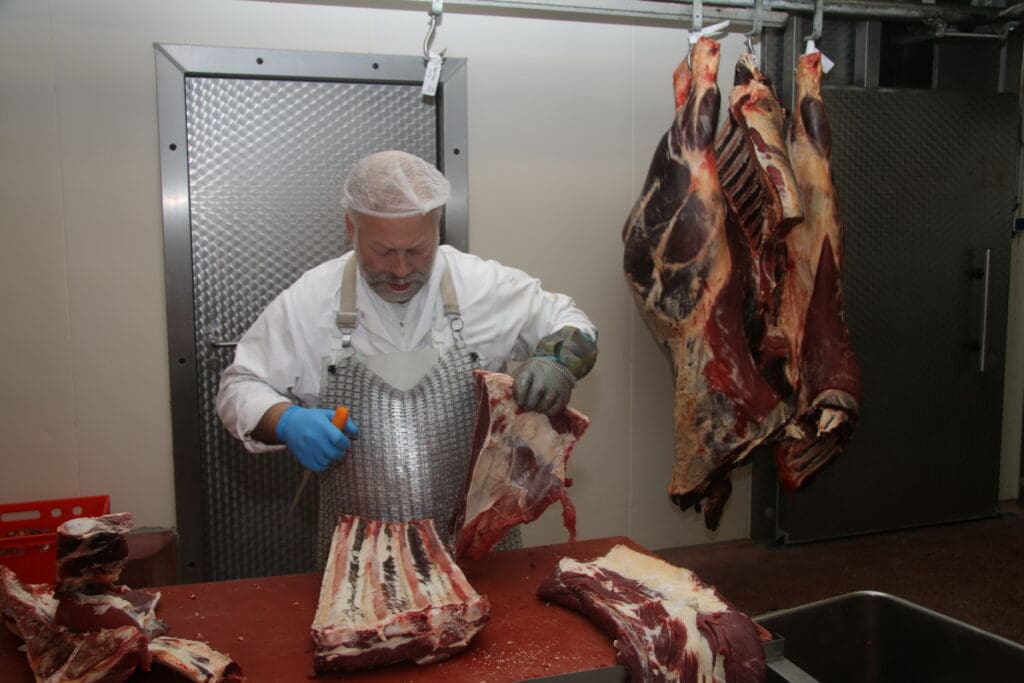 Im Zerlegeraum: Fleischer  Kay Uhn trennt hier Teile  einer Rinderbrust von den  Rippen. Uhn ist gelernter  Fleischer und seit Juli  vergangenen Jahres einer von  vier Mitarbeitern im Ökoschlachthaus Wismar. 