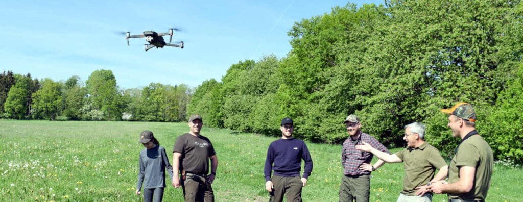 Drohne fliegt über Wiese zur Kitzrettung während der Futterernte