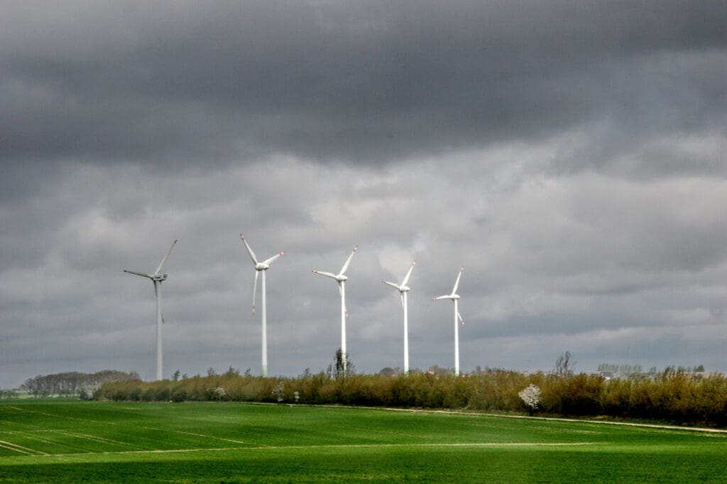 Fünf Windräder vor dunklem Wolkenhimmel
