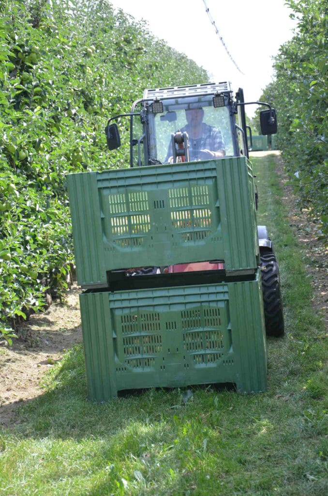 Ein Traktor mit mehreren Kisten für verschiedenes Obst wie Äpfel oder Pflaumen.
