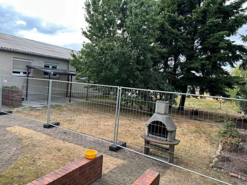 Blick aus dem Fenster auf den Hof. Seit Ende Juni waren die Noacks durch die Bauzäune in ihrem Bewegungsradius sichtlich eingeschränkt. Die Nebengebäude waren passé, eine Kamera (r.) überwachte das Geschehen. © Heike Mildner