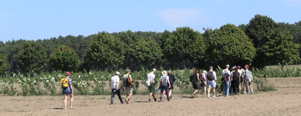 Die Teilnehmer--Gruppe der Agroforst-Exkursion auf einer jungen Obstbaufläche.